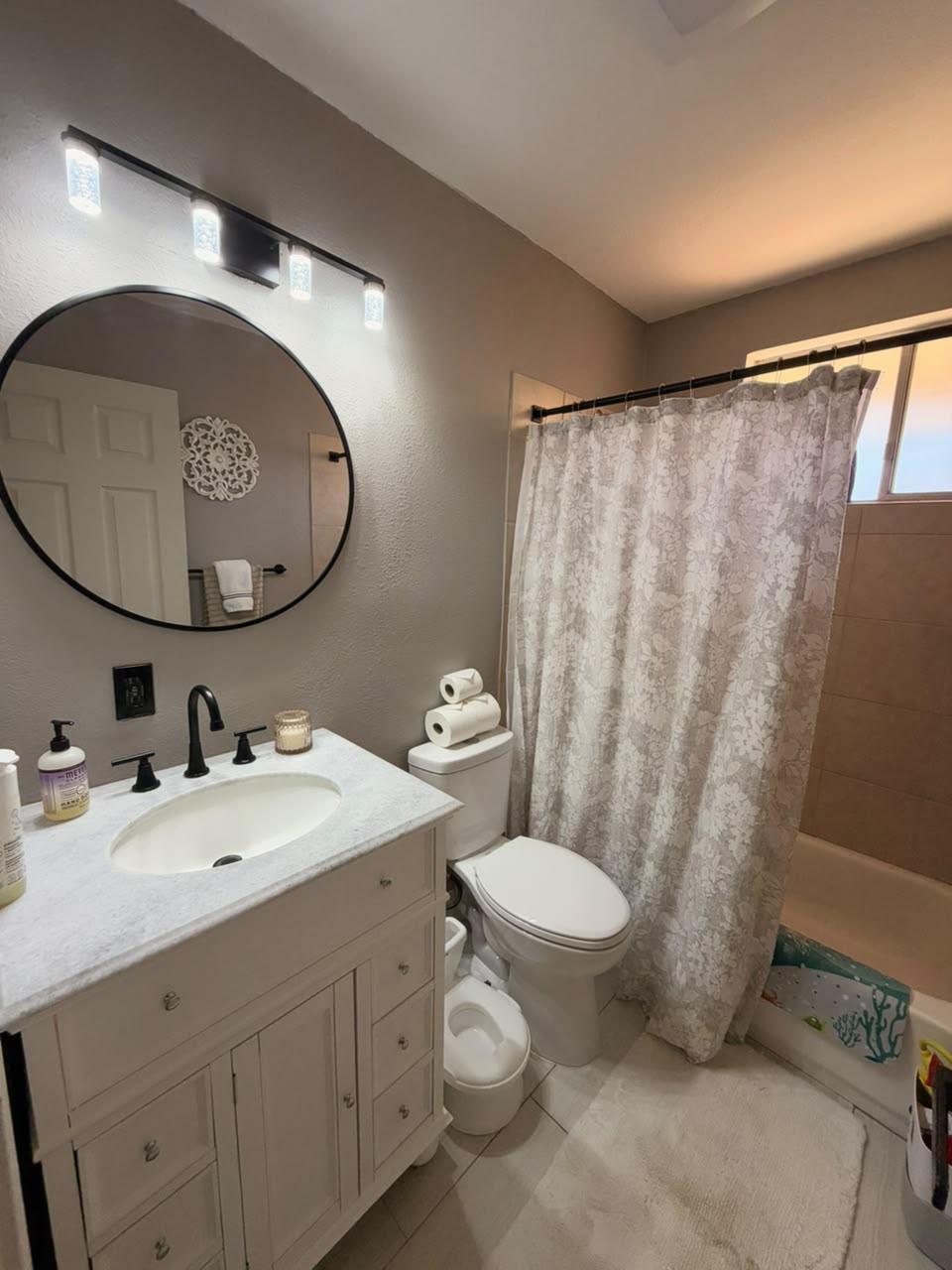 Clean bathroom with vanity and tiled shower