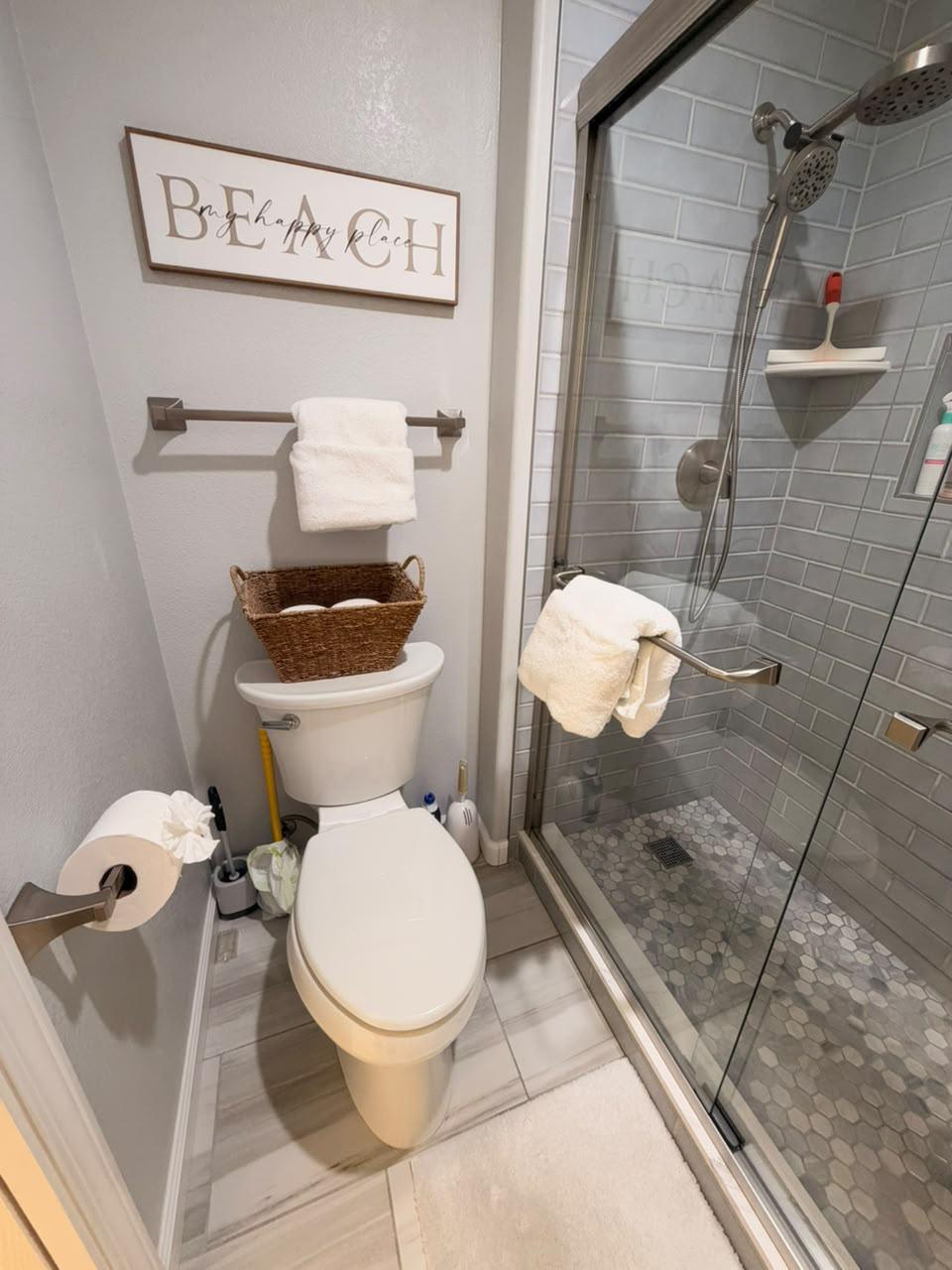 Clean glass shower with subway tile and fresh towels