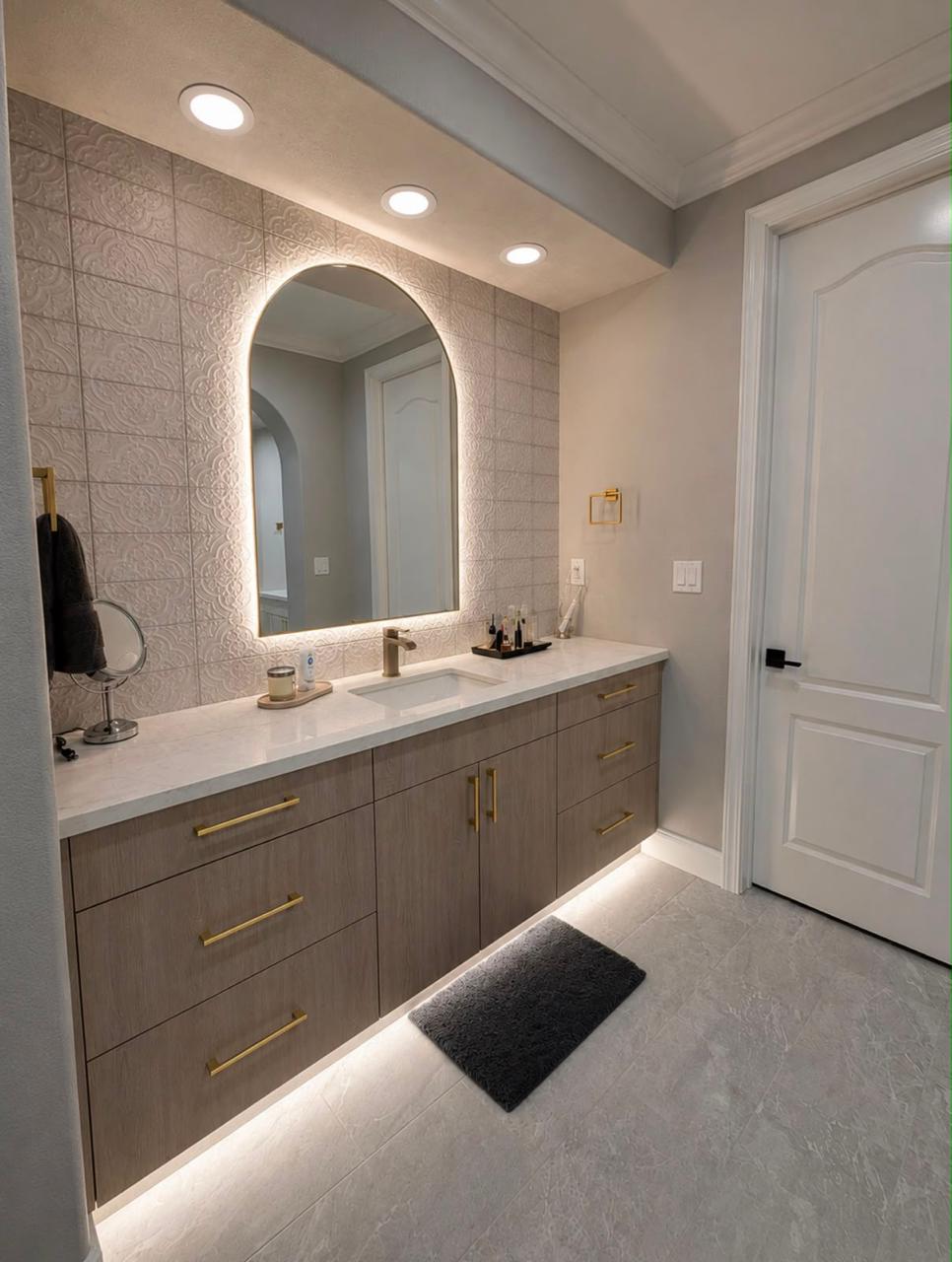 Polished bathroom vanity and illuminated mirror