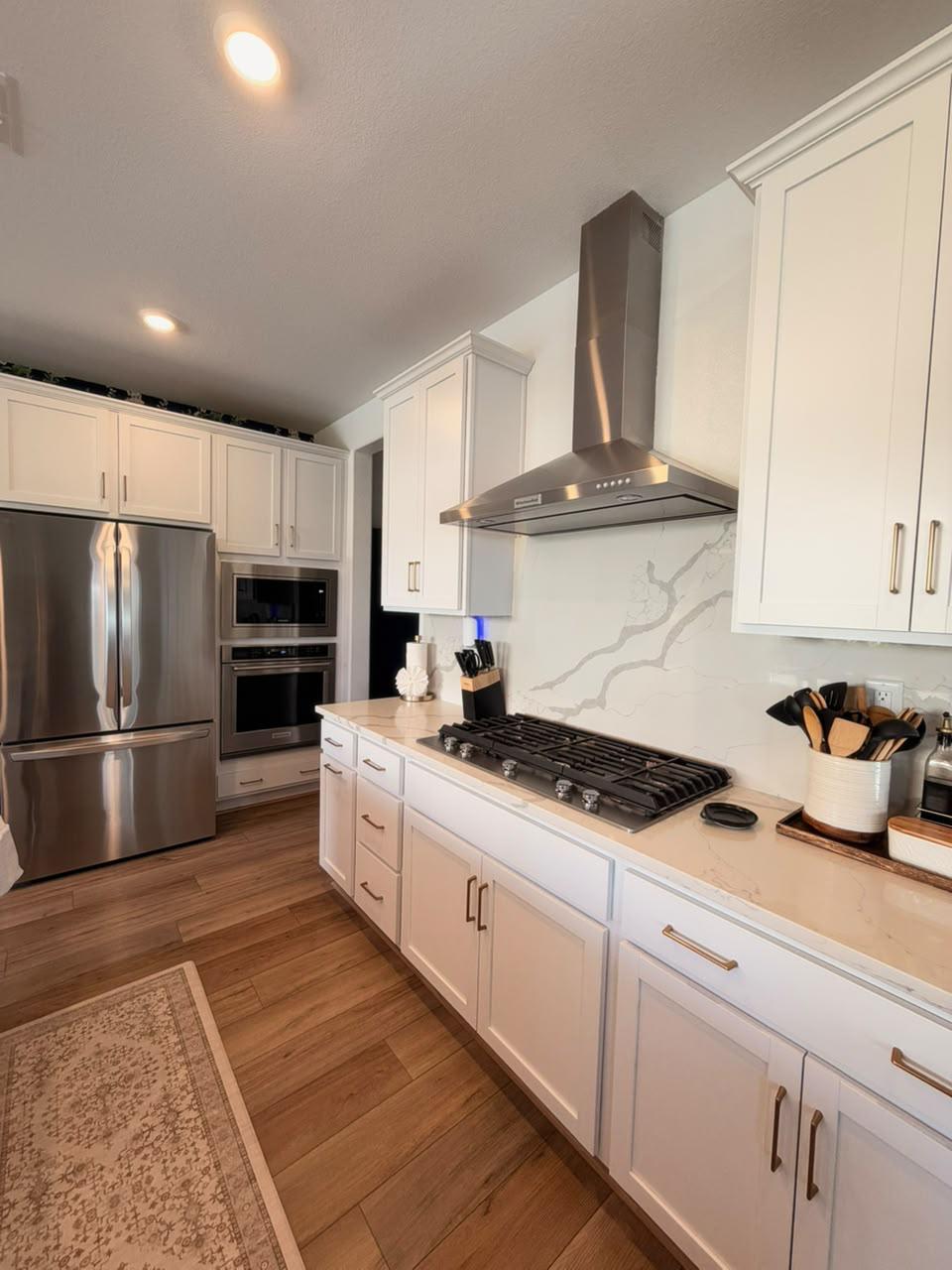 White kitchen with clean counters and stainless appliances
